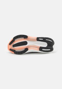 Hardloopschoen zool met een zwarte rubberen loopvlak, witte foam tussenzool, doorschijnende accenten en een oranje gedeelte bij de hak.