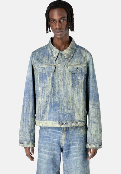 Chaqueta de denim con un patrón de rayas azul claro y amarillo, presenta un cuello tipo polo, dos bolsillos en el pecho y detalles de botones.