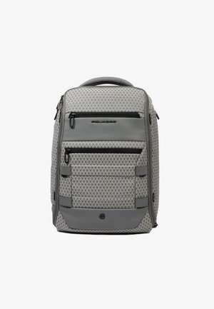 Mochila gris con un patrón geométrico, múltiples bolsillos con cremallera, base reforzada, paneles texturizados y asa acolchada.