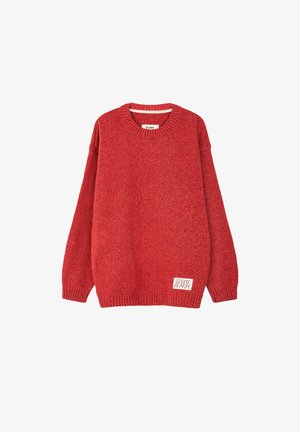 Czerwony sweter z dzianiny o okrągłym dekolcie, ze ściągaczami przy mankietach i dolnym brzegu, z małą białą prostokątną metką blisko dolnego brzegu.