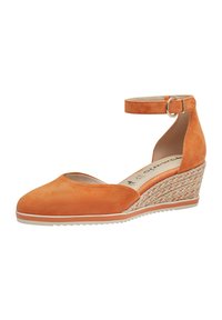 Chaussure compensée en daim orange avec une sangle autour de la cheville et une boucle circulaire. La semelle compensée présente une texture tissée, un socle blanc contrastant et un design de bout rond.