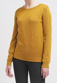 Mosterdgele gebreide trui met lange mouwen, ronde hals, geribbelde manchetten en zoom, met een zachte textuur en een slim fit.