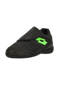 Svarta sportskor med en slät ovandel i läder, med diagonala sömmar och en grön logotyp. Slip-on-design utan snörning. Gummisula.