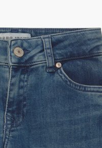 Dark blue denim jeans featuring a smooth texture, classic five-pocket design, and a metallic button closure at the waistband.