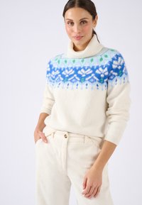 Maglione bianco con un colletto alto e a coste, caratterizzato da un motivo di fiocchi di neve blu, verde e bianco sul petto. Polsini e orlo a coste.