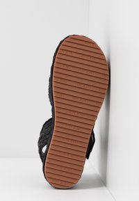 Svart sandal med vävd överdel och texturerad gummisula. Har präglad "PEPE JEANS"-logotyp och grepplinjer.