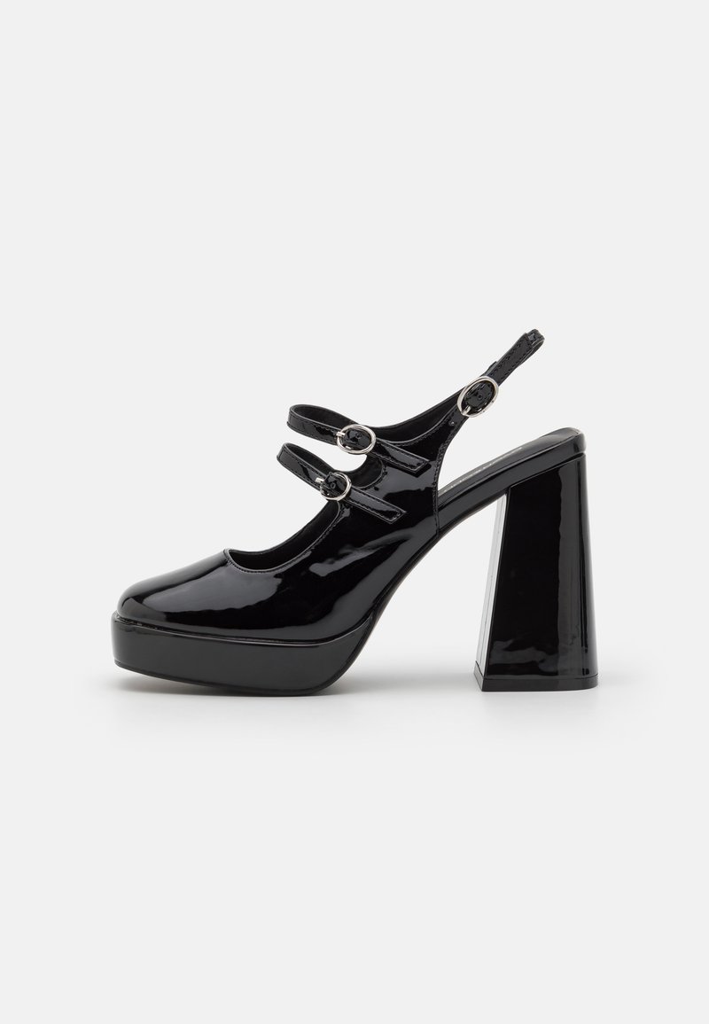 Black patent leather platform heels with a chunky block heel, featuring two adjustable straps with round silver hardware accents.