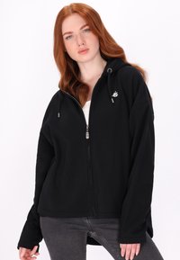 Zwarte rits hoodie met een ontspannen pasvorm, voorzien van een capuchon, koordjes en een klein wit logo op de borst. Zacht materiaal en lange mouwen.
