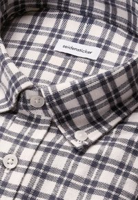 Camicia a quadri in cotone con motivo a check blu navy e bianco, colletto con bottoni e bottoni in plastica bianca con etichetta del marchio all'interno.