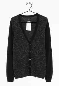 Cardigan en tricot noir et gris avec un col en V, des manches longues, une fermeture à six boutons et un corps texturé. Suspendu à un crochet noir.