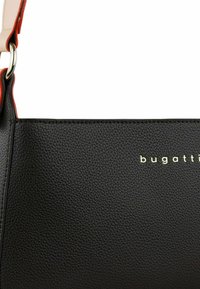 Borsa a tracolla in pelle nera strutturata con logo "bugatti" in oro, caratterizzata da una finitura rossa a contrasto e una tracolla removibile.
