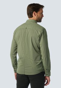 Grünes karierter Langarmhemd mit Knopfmanschetten und Kragen, das ein subtil strukturiertes Muster, sichtbare Nähte und einen Knopf im Rückenteil aufweist.