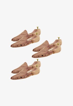 Drei Paar Holzschuhspanner mit Messingknöpfen, angeordnet in einem versetzten Muster auf weißem Hintergrund.