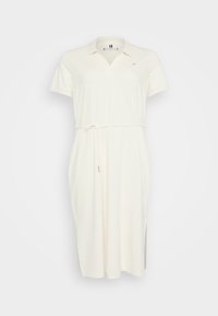 Vestido polo color crema con escote en V y mangas cortas. Presenta un cinturón de lazo en la cintura y aberturas en los laterales. Fabricado en suave material de algodón.