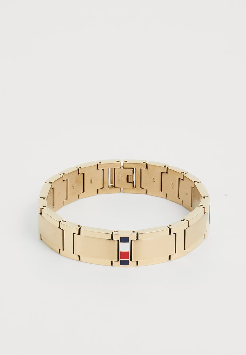 Gold-toned metal bracelet with interconnected rectangular links and a central enamel accent featuring red, white, and blue stripes.