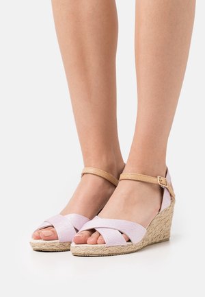Sandali a zeppa con tomaia in tessuto rosa a strisce incrociate e cinturino beige alla caviglia, dotati di suola in juta intrecciata. Design open-toe.