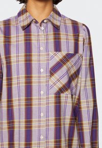 Plaid button-up shirt featuring purple, yellow, and brown stripes. Material appears soft with a chest pocket detail.
