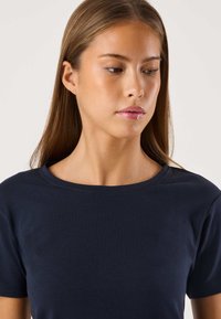 Laivastonsininen, lyhythihainen t-paita sileästä puuvillasekoitteesta, pyöreällä pääntiellä ja minimalistisella designilla. Ei näkyviä kuvioita tai korostuksia.