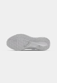 Shoe sole with textured rubber grip, predominantly white color, featuring a patterned tread design for traction and stability.