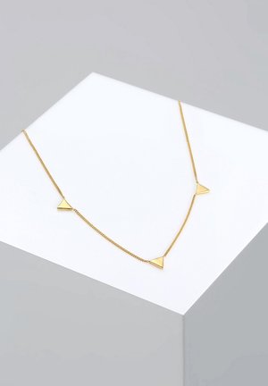 Zarte goldene Halskette mit drei kleinen, gleichmäßig verteilten dreieckigen Anhängern, präsentiert auf einer weißen schrägen Fläche.