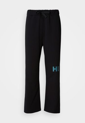 Schwarze Jogginghose mit Kordelzug in der Taille, mit weitem Hosenbein und türkisem "HUGO"-Schriftzug am linken Bein. Weiche Stofftextur.