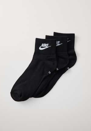 Três pares de meias de algodão pretas com punhos canelados. Cada meia apresenta um logo branco da Nike na parte da frente. Textura suave, design atlético padrão.