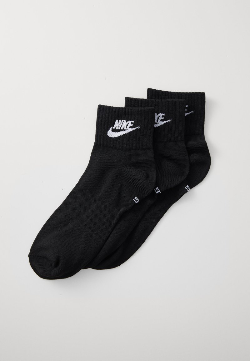 Trei perechi de șosete negre din bumbac cu manșete ribbate. Fiecare șosetă are un logo alb Nike pe față. Textură netedă, design athletic standard.
