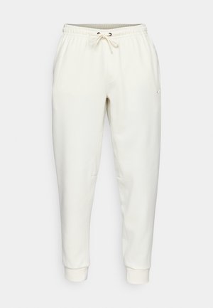 Hvide sweatpants med snoretræk i taljen, smalle ben, sidelommer og et lille logo. Fremstillet af blødt, glat stof.
