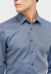 Blauw overhemd met een geometrisch patroon, voorzien van een button-down kraag en bijpassende knopen, gemaakt van een zachte stof met een subtiele glans.