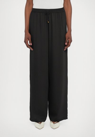 Zwarte wijde broek met een elastische tailleband en een trekkoord. Gemaakt van een gladde stof, met een relaxte pasvorm en een minimalistisch ontwerp.