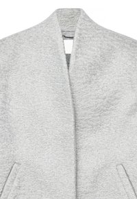 Abrigo de lana texturizada gris claro con solapas anchas y bolsillos frontales en ángulo, mostrado desde el torso superior para resaltar el detalle de la tela.