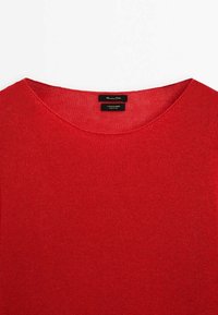 Pull en mélange de coton rouge avec un col rond et une texture côtelée. Présente une étiquette avec le texte "Massimo Dutti" et "Mélange de coton".