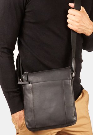 Black leather messenger bag with a flat design, adjustable strap, and a zip closure. Features smooth texture and a subtle horizontal seam detail.