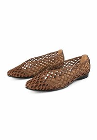 Zapatos planos de cuero marrón trenzado con un diseño de malla, punta afilada y suela de goma negra. En el interior tienen un forro suave color marrón claro.