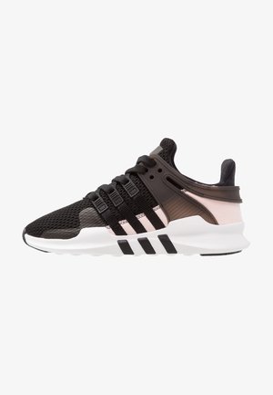 Baskets de sport noires et roses avec dessus en mesh, lacets noirs, cage latérale en plastique et semelle blanche à rayures noires.