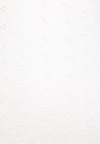 Bílá tkanina s vyvýšeným, texturovaným květinovým vzorem. Obsahuje zakřivené linie a kruhové detaily; hladký povrch s jemnou výšivkou.