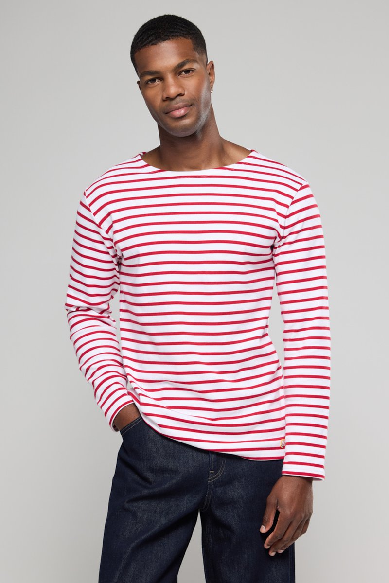 Rød- og hvidstribet langærmet skjorte lavet af blødt stof, med bådudskæring og afslappet pasform, parret med mørke denimbukser.