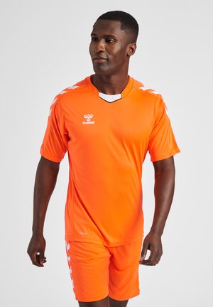 Completo da calcio arancione brillante realizzato in materiale leggero, con colletto a V e dettagli bianchi sulle spalle. I pantaloni corti sono abbinati alla maglia.
