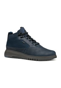 Zapatillas altas de marina con parte superior de cuero liso, panel de malla texturizada, cordones negros y una gruesa suela gris acolchada.