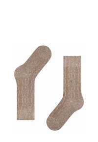 Brązowe skarpetki w wzorki, wykonane z teksturowanego materiału. Jedna ma zaokrąglony czubek, podczas gdy druga ma prążkowaną górną część i okrągłą ozdobę.