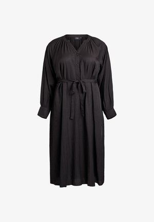 Robe noire à manches longues en tissu texturé, avec un décolleté en V, des boutons à l'avant et une taille nouée, présentant une silhouette ample et fluide.