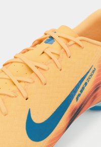 Nike Air Zoom jalgpalliketsid erksas oranzis siniste aktsentidega, tekstureeritud pind ja mustriline detail külgedel.