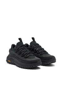 Mustat vaelluskengät, joissa on teksturoitu päällinen, vahvistettu kärki ja paksut pohjat. Varustettu kestävillä nauhoilla ja keltaisella Vibram-logolla.