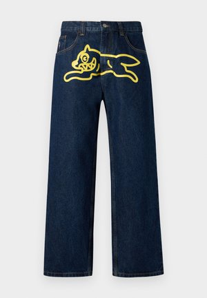 Dark blue denim jeans featuring a large yellow graphic of a leaping character on the back pocket. Straight leg design with standard stitching.