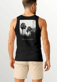 Schwarzes Tanktop mit einem weißen Grafikdesign von Palmen, einem strukturierten Hintergrund und dem Text "Nimm mich mit ins Paradies" darunter.