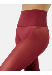 Leggings burdeos de cintura alta con una textura suave, que presentan un diseño sin costuras y una forma ajustada, ideales para el uso activo.