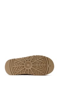 Bruine rubberen buitenzool met een gestructureerd profiel met hoekige vormen en een ronde middendetail. Zachte randen, duurzaam ontwerp.