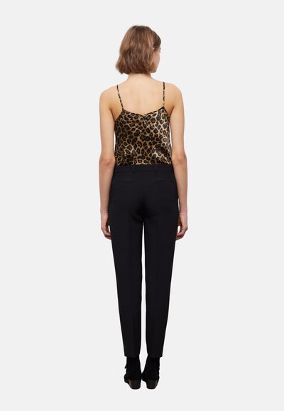 Leopardprint satijnen camisole met dunne bandjes, gecombineerd met op maat gemaakte zwarte broeken, aansluitende silhoe tte, gladde textuur en discrete achterzakken.