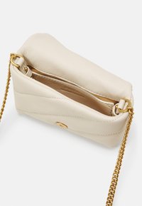 Borsa in pelle beige con tracolla in catena dorata, forma arrotondata e chiusura superiore. Interno foderato con tessuto chiaro.