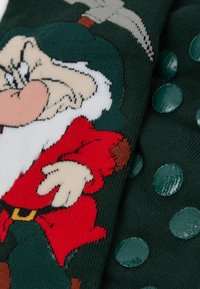Grønne sokker med et cartoon dværg design i rød og hvid, med forhøjede grønne polka prikker. Blødt strikkemateriale, hyggelig tekstur.